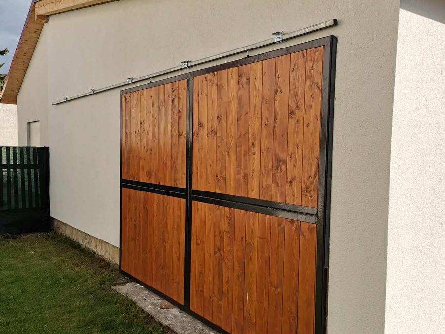 Detail horního vedení a rámu posuvných vrat s dřevěnou výplní